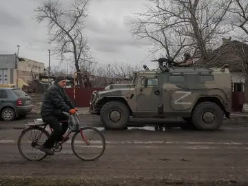 Un hombre en bicicleta se cruza con un tanque ruso en Ucrania