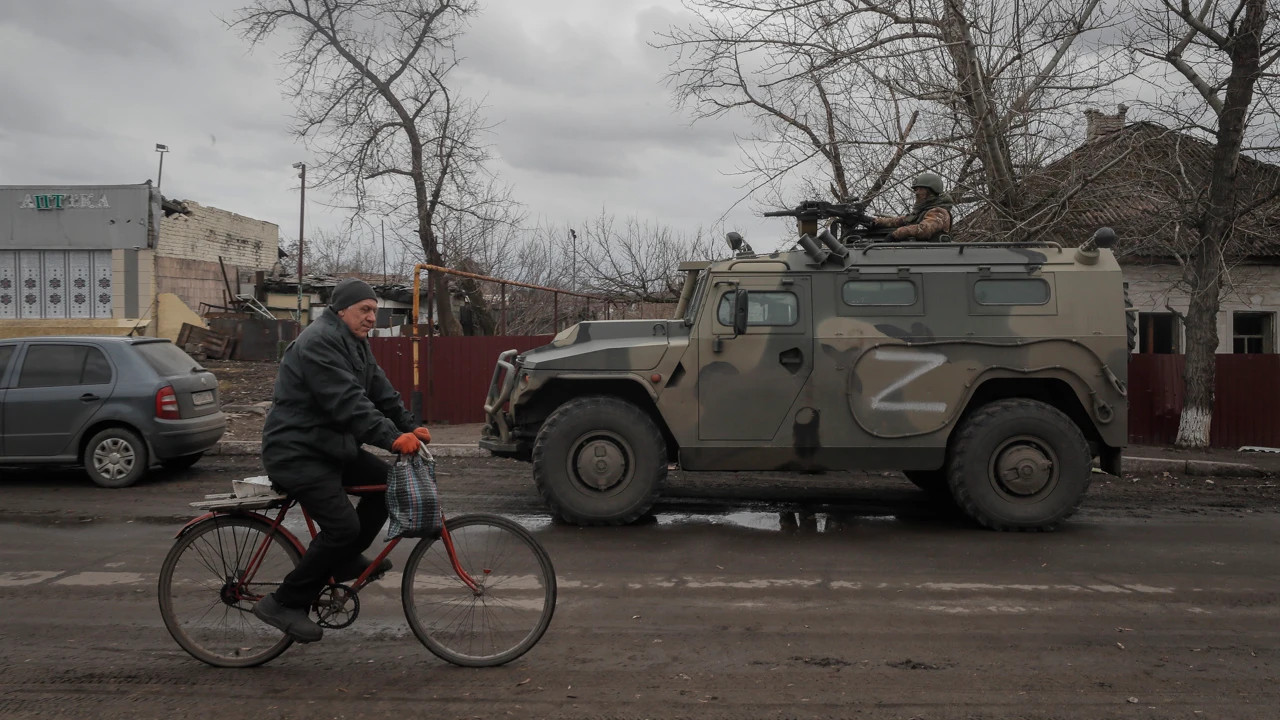 Un hombre en bicicleta se cruza con un tanque ruso en Ucrania