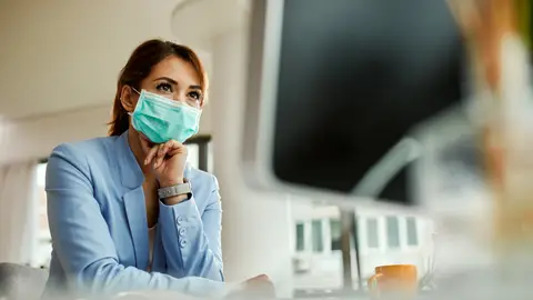 Mujer con mascarilla en un espacio interior Mujer con mascarilla en un espacio interior