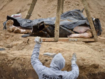 Un operario exhuma un cadáver en Ucrania