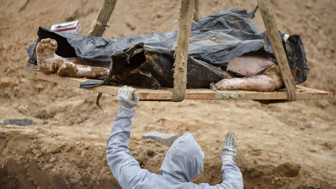 Un operario exhuma un cadáver en Ucrania Un operario exhuma un cadáver en Ucrania