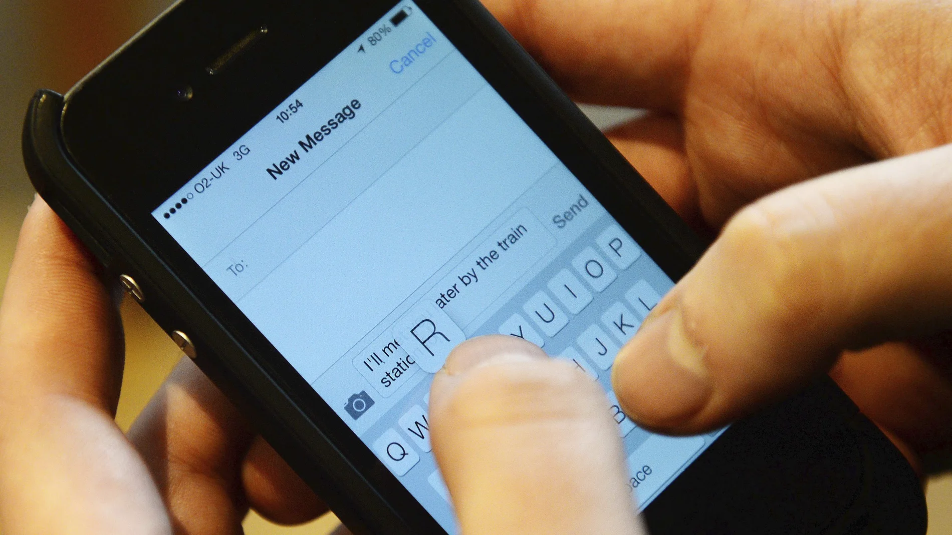 Un hombre escribe un mensaje de texto en su teléfono móvil, en una fotografía de archivo