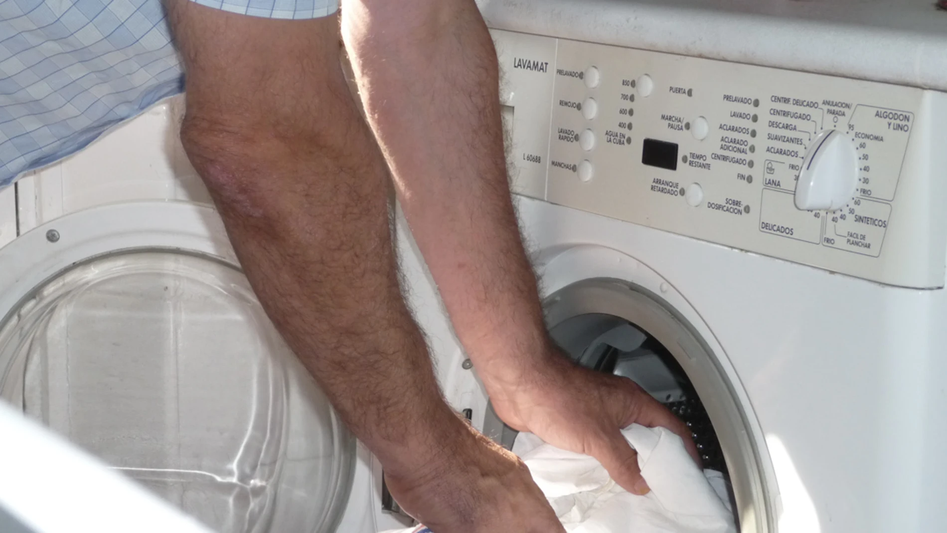 Un hombre pone la lavadora Un hombre pone la lavadora