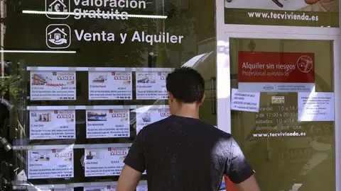 Un joven mira los anuncios de ventas de casa Un joven mira los anuncios de ventas de casa