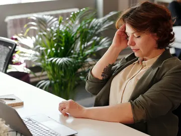 Mujer con dolor de cabeza en la oficina. Mujer con dolor de cabeza en la oficina.