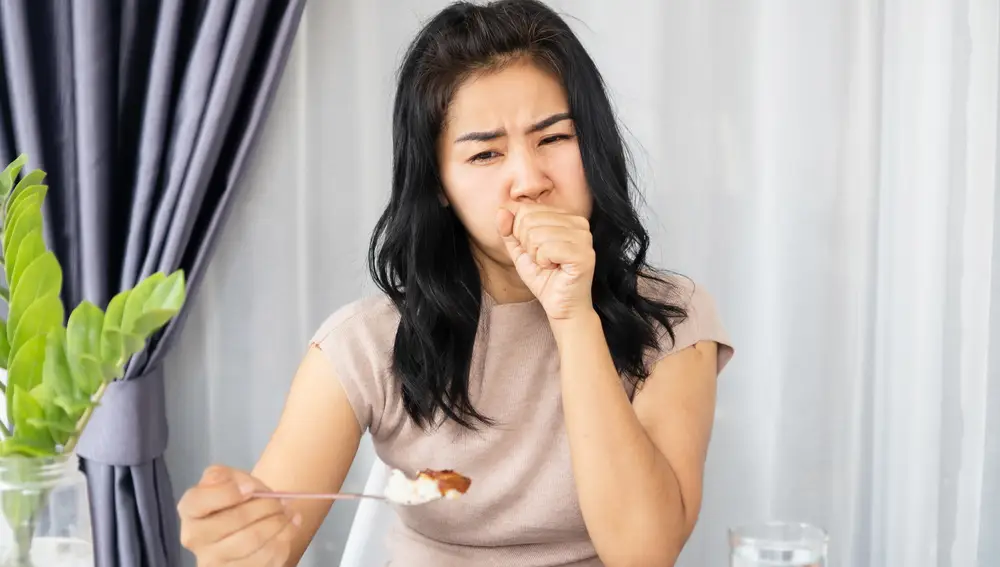 Mujer que se atraganta al comer