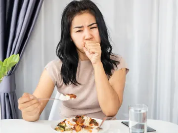 Mujer que se atraganta al comer Mujer que se atraganta al comer