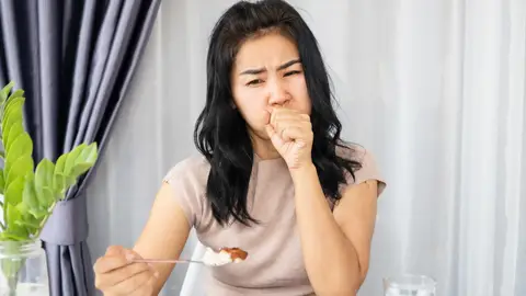 Mujer que se atraganta al comer Mujer que se atraganta al comer