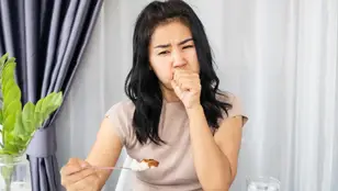 Mujer que se atraganta al comer