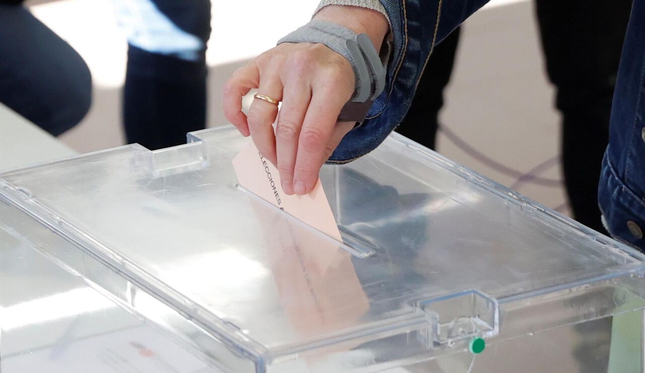 Persona introduciendo su voto en la urna