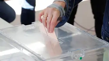 Persona introduciendo su voto en la urna