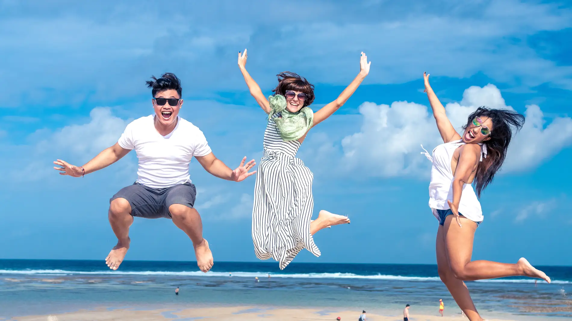 Jóvenes saltando en la playa.