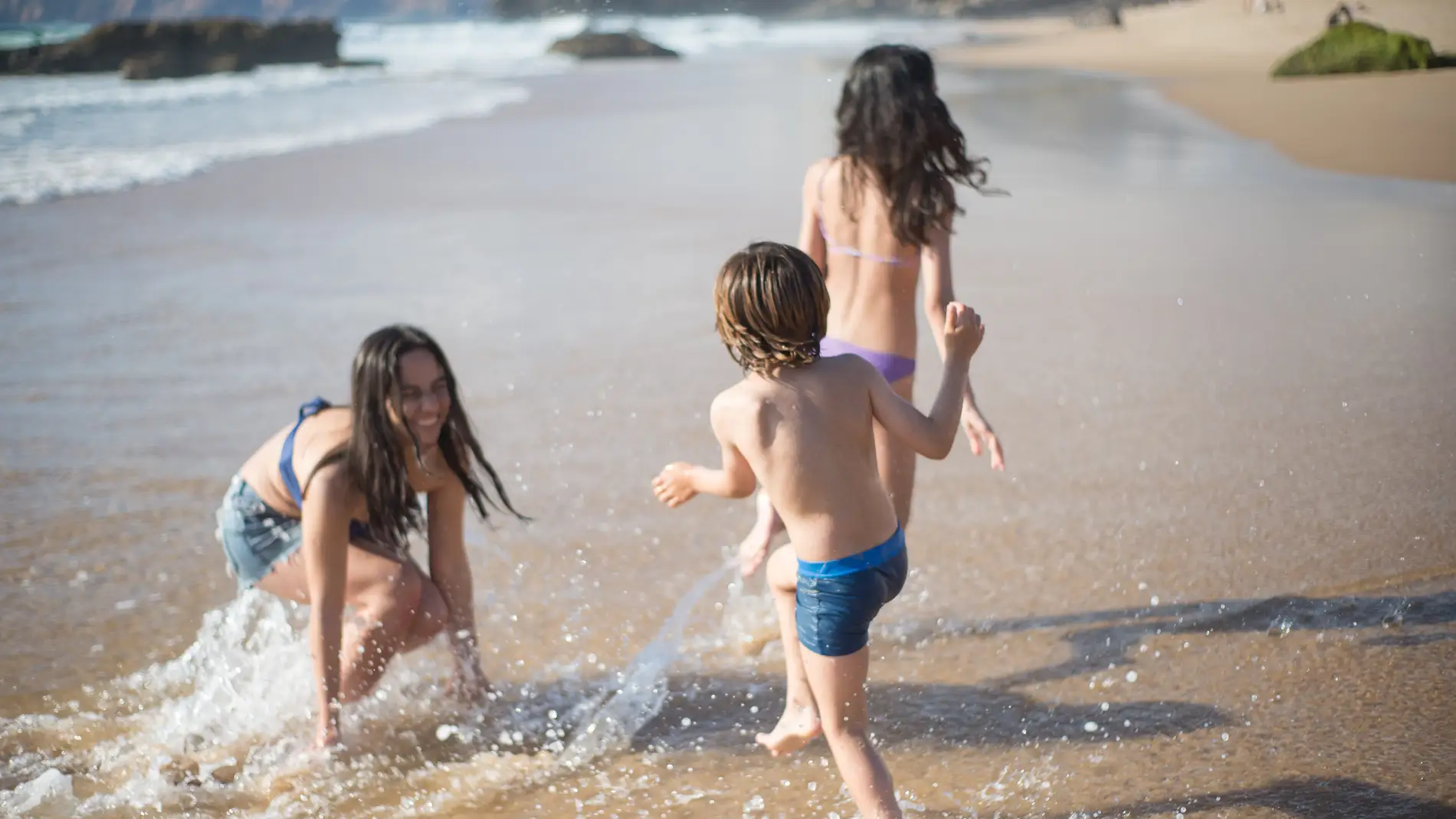 Niños y niñas en la playa.