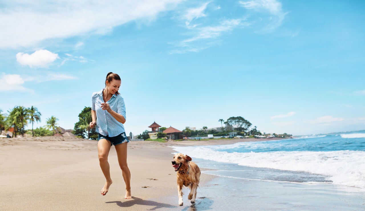 Chica en la playa con el perro
