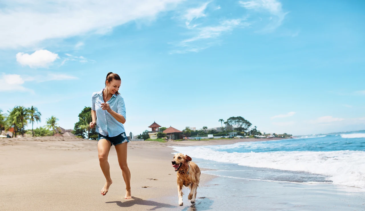 Chica en la playa con el perro