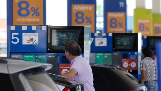 Dos personas repostan en una gasolinera de Madrid