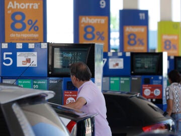 Dos personas repostan en una gasolinera de Madrid