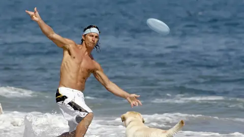 Matthew McConaughey lanza un frisbee a un perro en la playa Matthew McConaughey lanza un frisbee a un perro en la playa