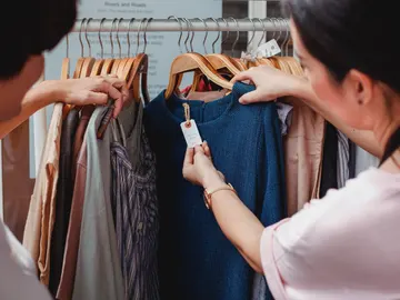 Mirando el precio de una prenda de ropa Mirando el precio de una prenda de ropa