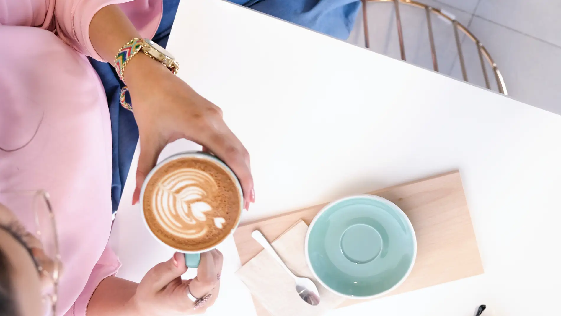 Chica tomando café en una mesa ordenada