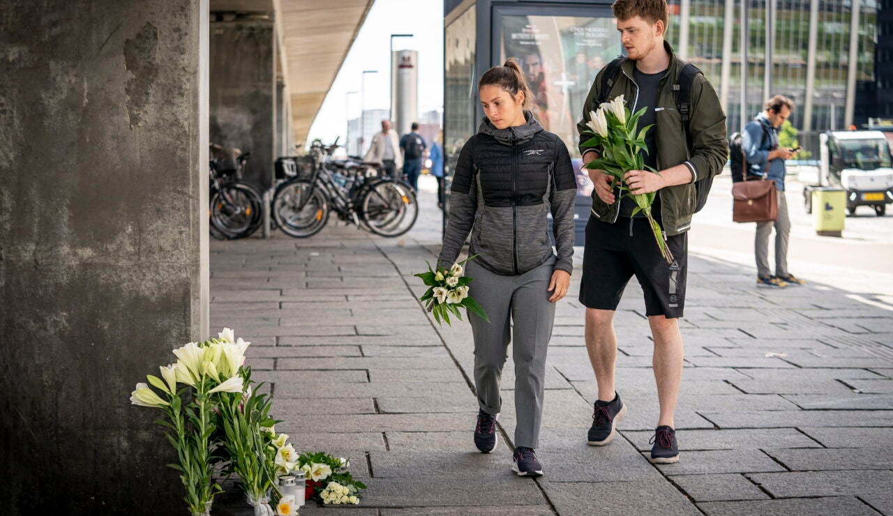 Ciudadanos dejan flores a la puerta del centro comercial de Copenhague