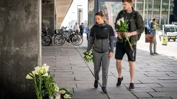 Ciudadanos dejan flores a la puerta del centro comercial de Copenhague