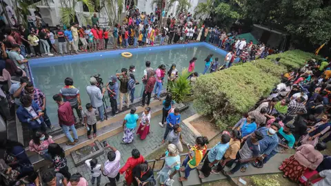 Los ciudadanos de Sri Lanka acuden a la residencia del presidente un día después de su asalto Un grupo de personas echa un vistazo y se da un chapuzón en una piscina del palacio presidencial en Colombo, Sri Lanka, el 10 de julio de 2022, un día después de que las residencias oficiales fueran asaltadas. El presidente y el primer ministro de Sri Lanka acordaron dimitir tras una reunión de líderes del partido durante una jornada de masivas protestas contra el gobierno. El 9 de julio, miles de manifestantes rompieron las barricadas policiales y asaltaron el palacio presidencial, la secretaría del presidente y las residencias oficiales del primer ministro. Las protestas llevan meses sacudiendo el país, pidiendo la dimisión del presidente y del primer ministro por la supuesta incapacidad de hacer frente a la peor crisis económica en décadas.