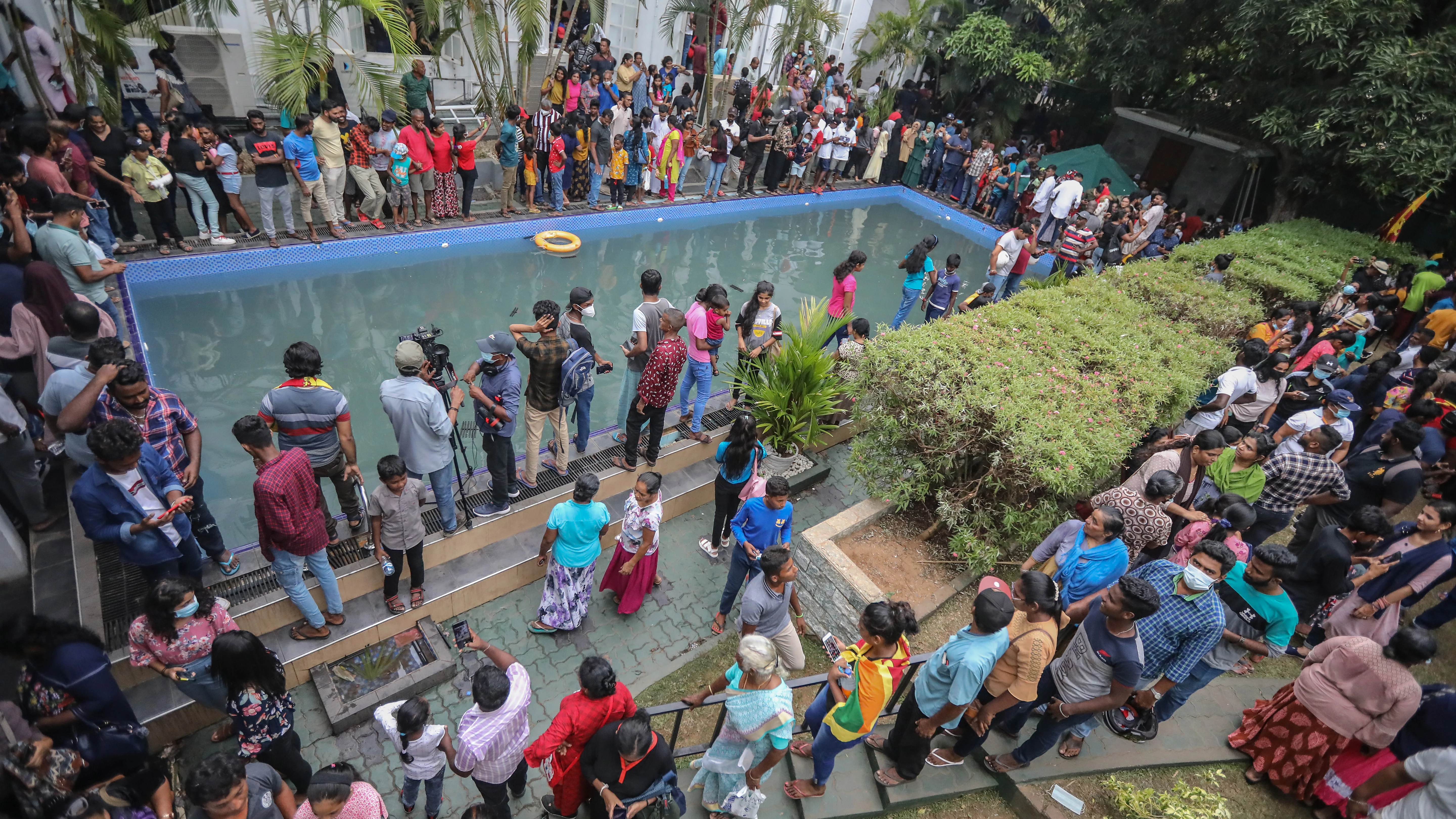 Los ciudadanos de Sri Lanka acuden a la residencia del presidente un día después de su asalto Un grupo de personas echa un vistazo y se da un chapuzón en una piscina del palacio presidencial en Colombo, Sri Lanka, el 10 de julio de 2022, un día después de que las residencias oficiales fueran asaltadas. El presidente y el primer ministro de Sri Lanka acordaron dimitir tras una reunión de líderes del partido durante una jornada de masivas protestas contra el gobierno. El 9 de julio, miles de manifestantes rompieron las barricadas policiales y asaltaron el palacio presidencial, la secretaría del presidente y las residencias oficiales del primer ministro. Las protestas llevan meses sacudiendo el país, pidiendo la dimisión del presidente y del primer ministro por la supuesta incapacidad de hacer frente a la peor crisis económica en décadas.