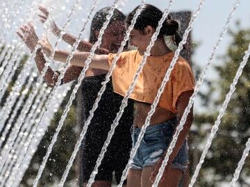 Dos jóvenes se refrescan durante la ola de calor