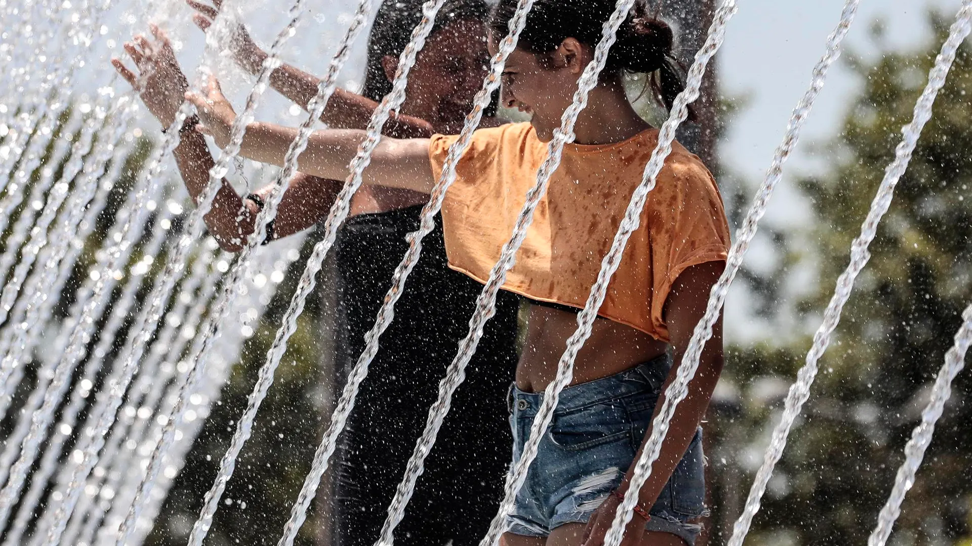 Dos j&oacute;venes se refrescan durante la ola de calor