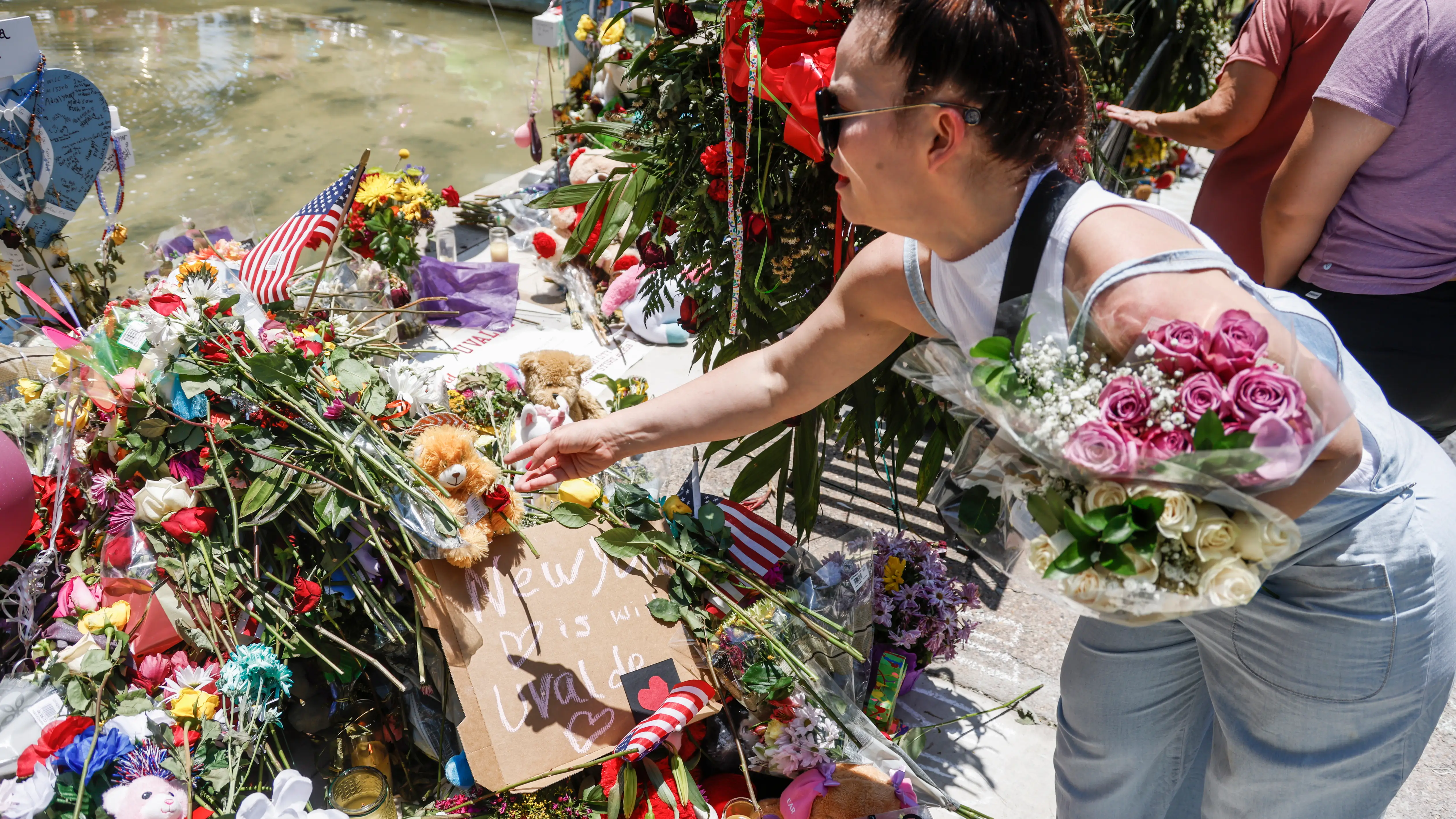 Una mujer al hacer una ofrenda floral frente a la institución académica Robb Elementary School, en Uvalde Una mujer al hacer una ofrenda floral frente a la institución académica Robb Elementary School, en Uvalde