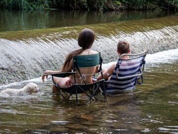 Dos jóvenes se refrescan en un río