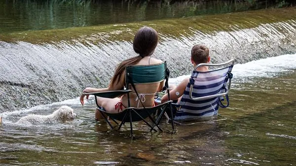 Dos jóvenes se refrescan en un río Dos jóvenes se refrescan en un río