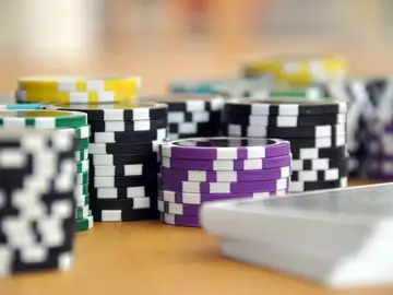 Fichas de casino junto a unas cartas Fichas de casino junto a unas cartas