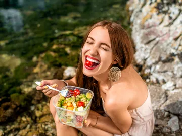 Una chica comiendo en la playa. Una chica comiendo en la playa.