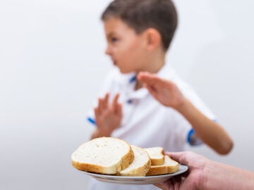 Un niño rechaza el pan blanco de trigo.