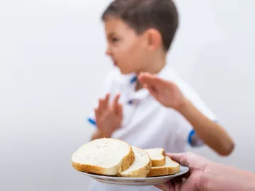 Un niño rechaza el pan blanco de trigo. Un niño rechaza el pan blanco de trigo.