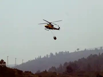 Un helicóptero realiza labores de extinción en el incendio de Puente de Domingo Flórez