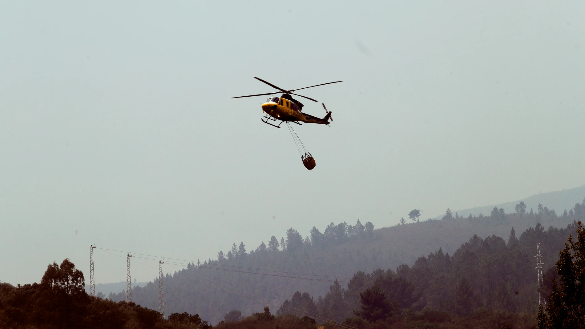 Un helicóptero realiza labores de extinción en el incendio de Puente de Domingo Flórez