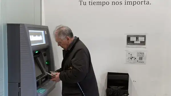 Un hombre retirando dinero del cajero Un hombre retirando dinero del cajero