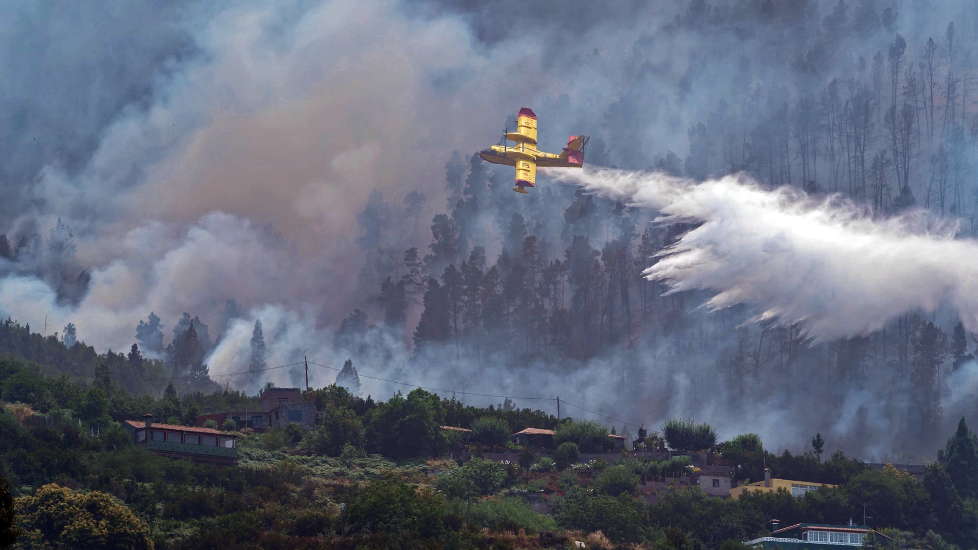 En la imagen, uno de los hidroaviones que participan en el operativo descarga agua sobre el incendio en Tenerife.