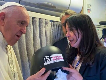 Captura de video del momento en el que el papa Francisco recibió hoy durante el vuelo hacia Canadá un casco de los que usó para sus coberturas el periodista español David Beriai