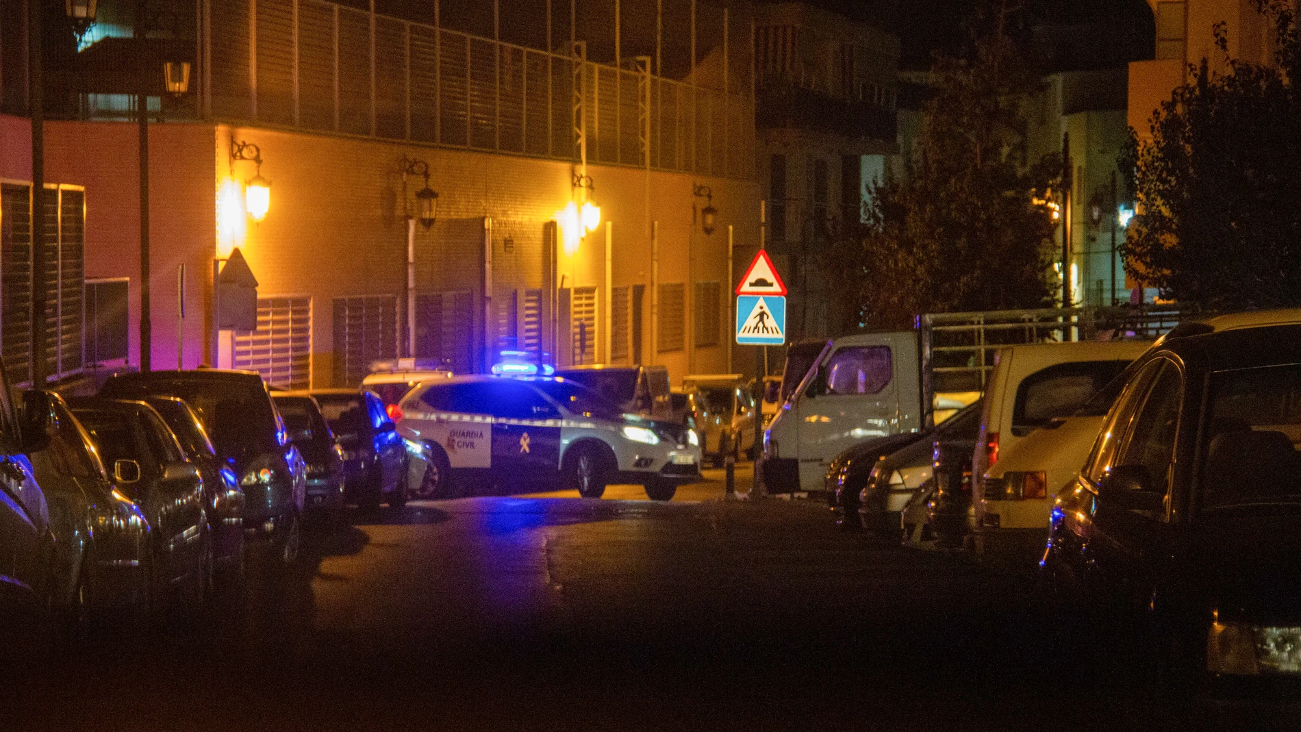 Un coche de la Guardia Civil vigila las inmediaciones de la vivienda donde han sido hallados muertos por arma de fuego un hombre y una mujer en Albuñol, Granada