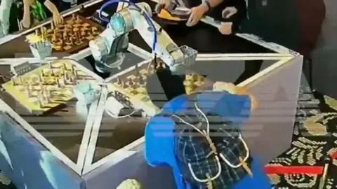 Niño jugando al ajedrez con un robot Niño jugando al ajedrez con un robot