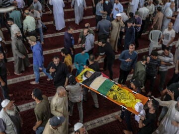 Un palestino lleva el cuerpo de una de las siete personas muertas en un ataque aéreo israelí