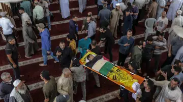 Un palestino lleva el cuerpo de una de las siete personas muertas en un ataque aéreo israelí