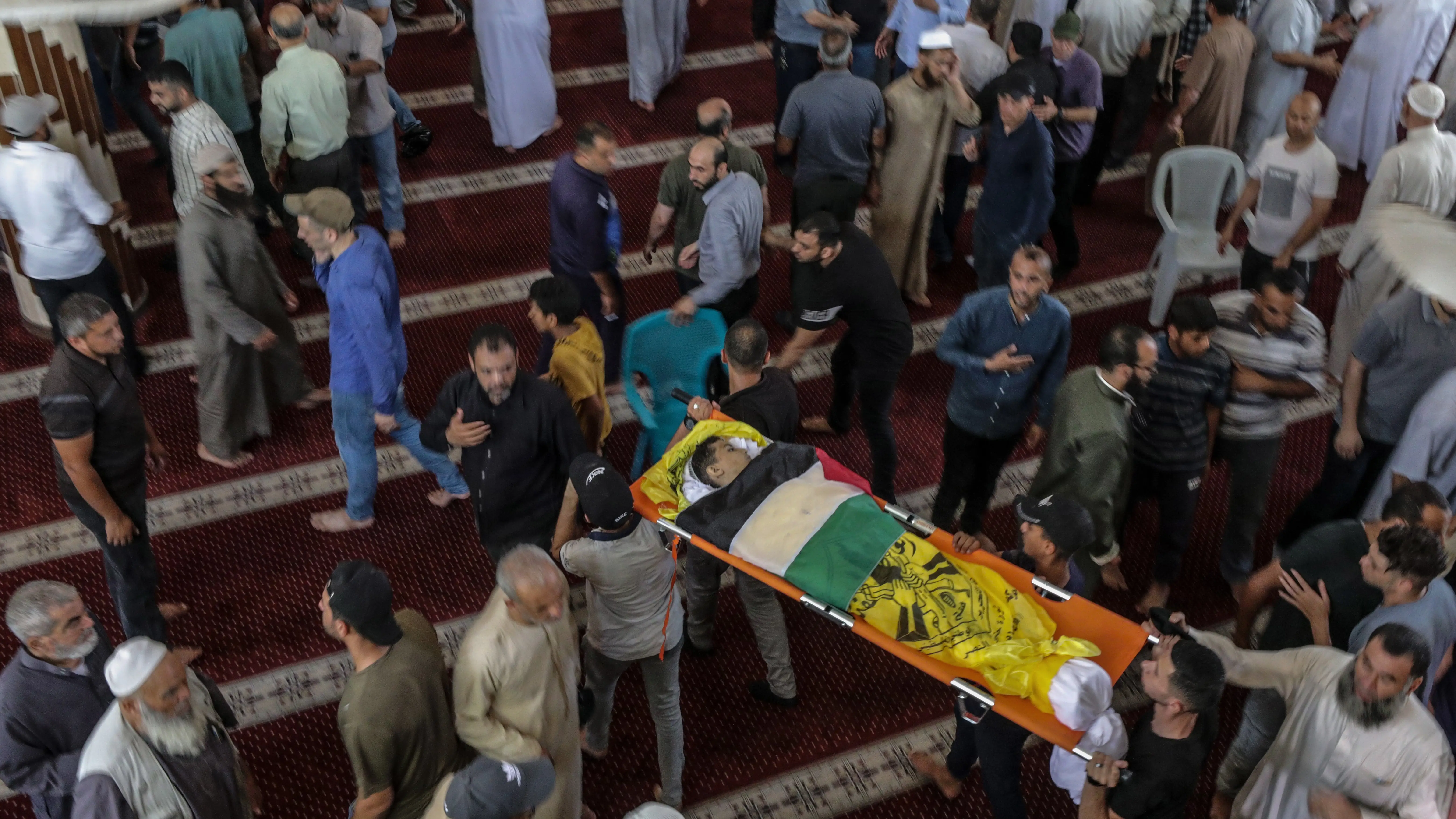 Un palestino lleva el cuerpo de una de las siete personas muertas en un ataque a&eacute;reo israel&iacute;