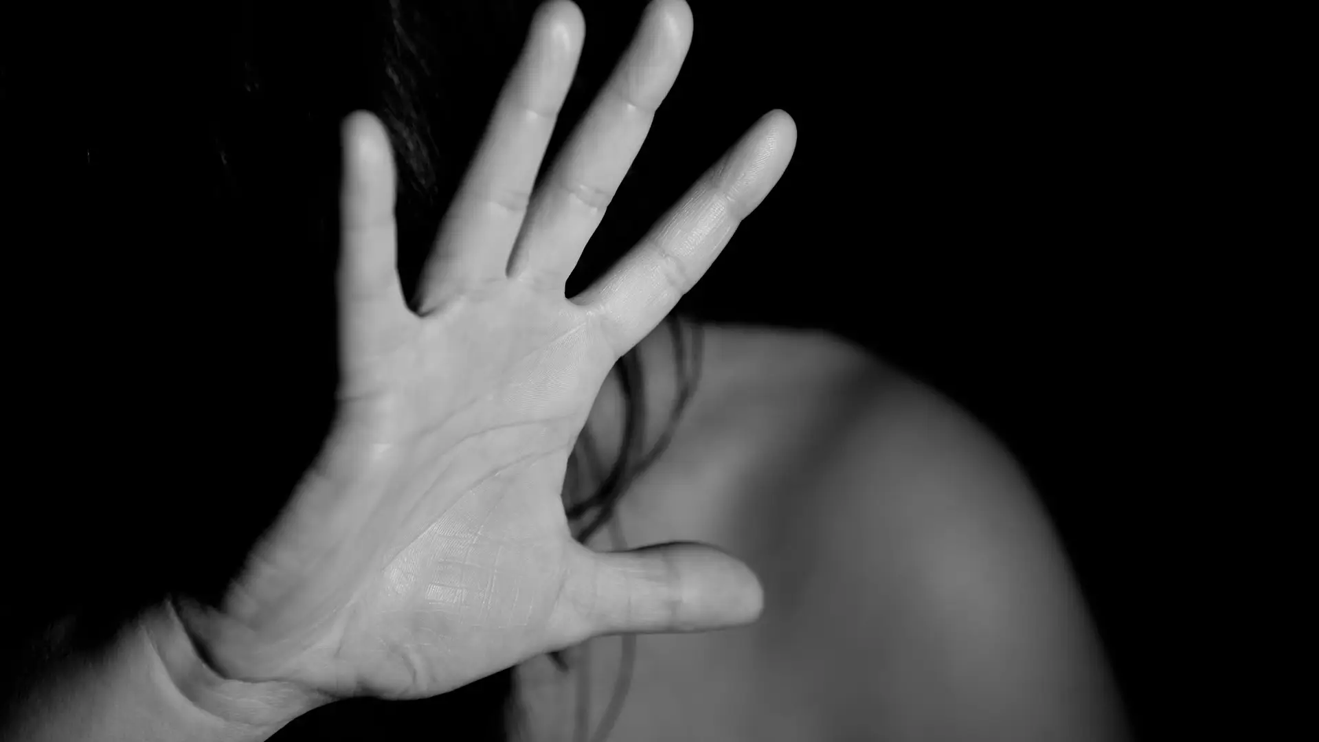 Mujer tapándose el rostro con su mano. Mujer tapándose el rostro con su mano.