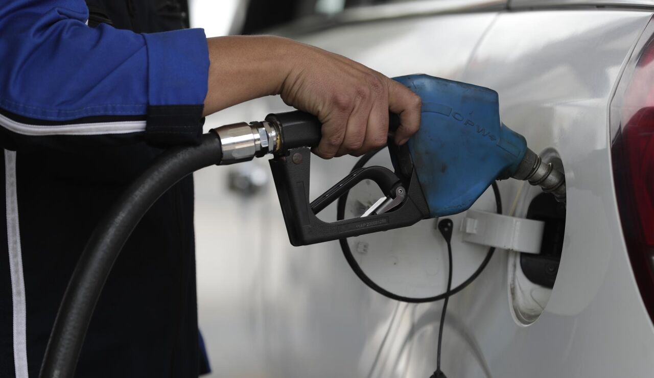 Un hombre pone gasolina a un vehículo