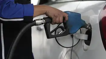 Un hombre pone gasolina a un vehículo Un hombre pone gasolina a un vehículo